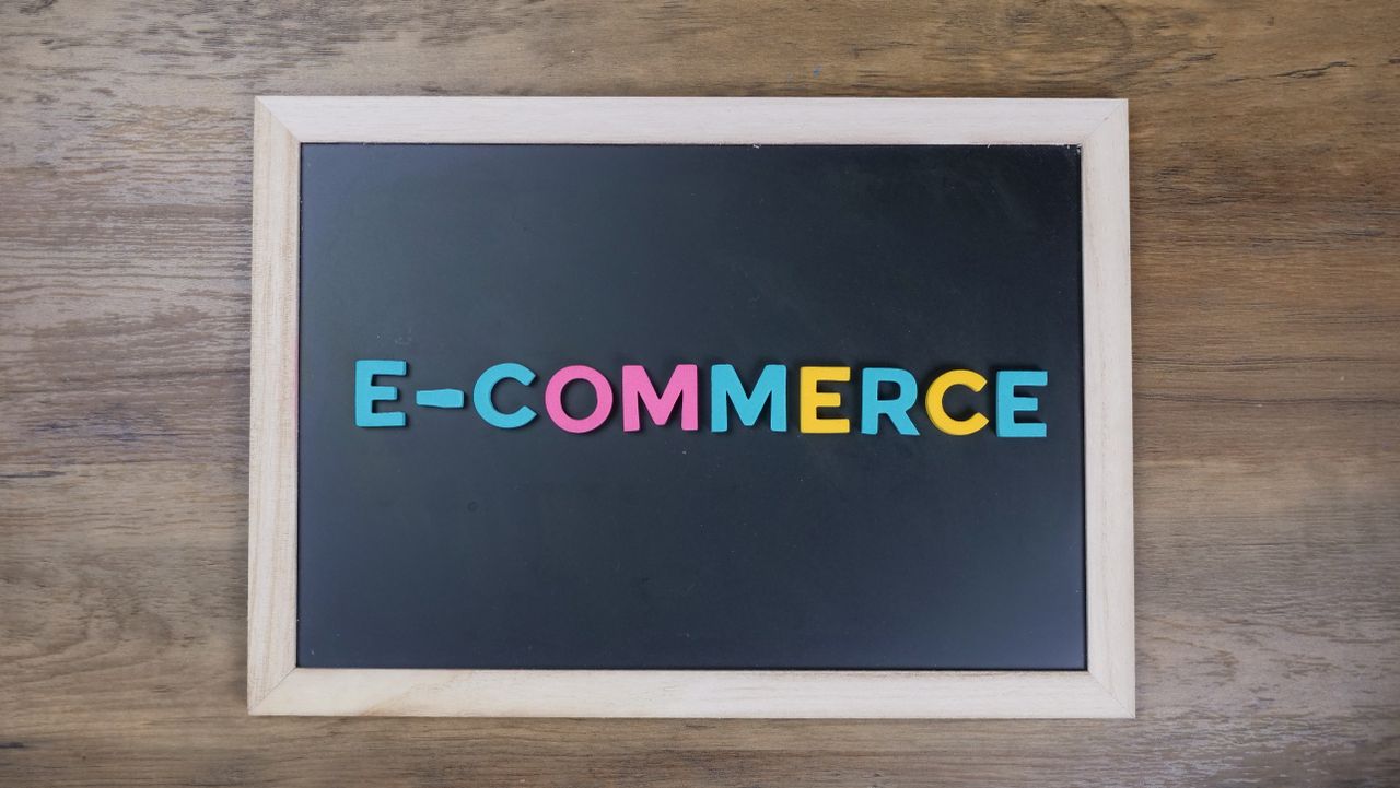 services-03 Colorful letters spelling e-commerce on a wooden framed blackboard.